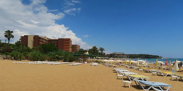 Ein Hotel und Liegestühle am Meer.