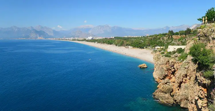 Der Blick von den Klippen am Konyaalti Strand auf den Strand und das dahinterliegende Taurusgbirge.