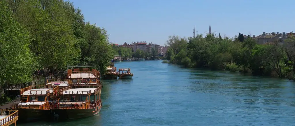 Der Manavgat Fluss im Zentrum der Stadt Manavgat mit Booten am Flussufer.