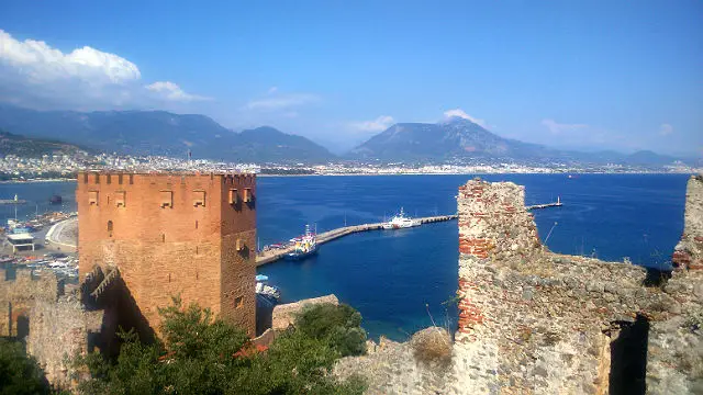 Blick auf den Roten Turm und den Hafen Roter Turm (Kizil Kule) von den Ruinen der Burgmauern am Burgberg von Alanya aus gesehen