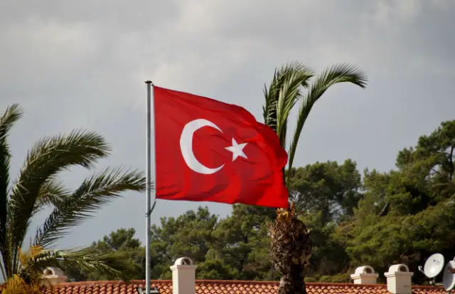 Auf einem Hausdach Flagge auf einem Masten am Hausdach