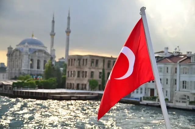 Flagge der Türkei am Heck eines Bootes. Im Hintergrund ist eine Moschee in Istanbul zu sehen
