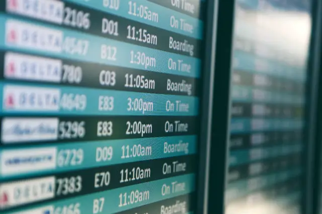 Anzeigentafel auf einem Flughafen. Die Farben sind in blau und schwarz gehalten. Die Schrift ist weiß. Es ist nur ein kleiner Teilbereich zu sehen. Das Bild ist aus etwa einem Meter Entfernung aufgenommen worden.