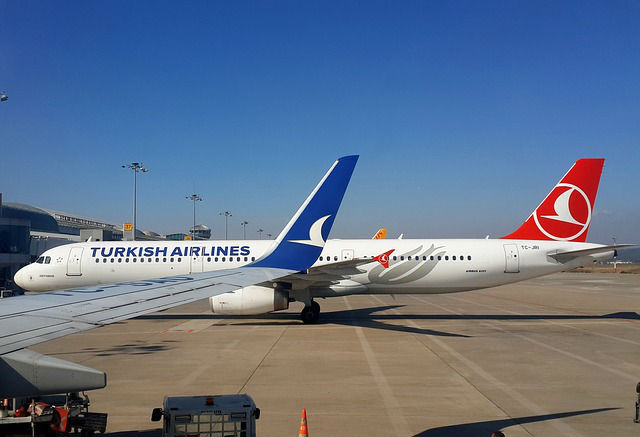 Flugzeug von Turkish Airlines steht an einem Flughafenparkplatz. Davor sind die Flügelspitzen eines anderen Flugzeugs zu sehen