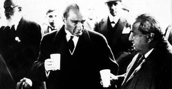 Schwarz-Weiß Foto von Mustafa Kemal Atatürk mit einem Becher Ayran in seiner Hand. 