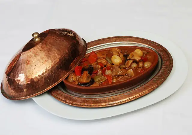 osmanisches Messing Geschirr Set mit Tasse, Platte und Deckel. Sie ist mit Essen gefüllt.