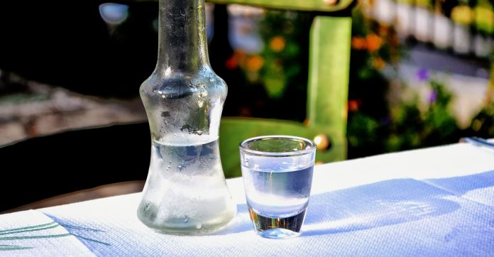 Raki in einem Krug mit einen Glas Raki auf einem Tisch