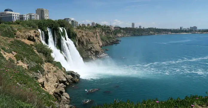 40 Meter hohe Klippen und das herabfallende Wasser des Düden Fluss. Aufgenommen von einem Park oberhalb der Klippen mit Blick aufs Meer hinunter