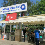 Eingang mit Kasse und Drehkreuz zum Düden Salalesi Park. Es ist eine türkische Flagge und ein weißes Banner mit der Aufschrift: Düden Waterfalls" zu sehen.