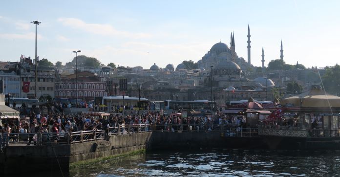 Blick von der Galatabrücke auf das südliche Ufer des Goldenen Horn. Neben den Streetfoodländen stehen hunderte Menschen. Im Hintergrund ist die Süleymaniye Moschee zu sehen. 