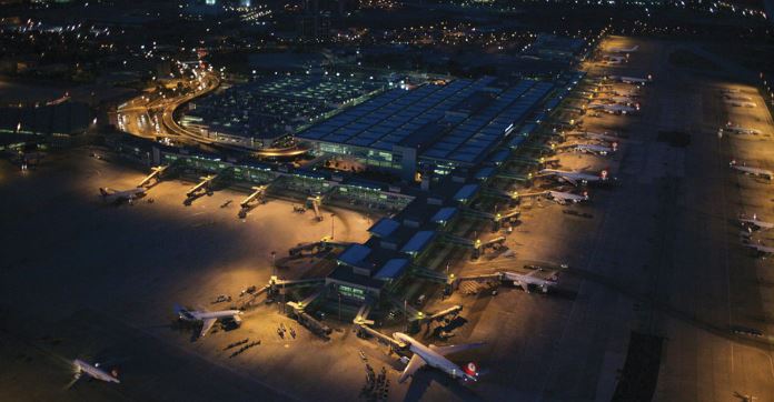 In der Nacht aufgenommenes Lufbild des Flughafen Istanbul Atatürk mit dem Hauptterminal und den dort stehenden Flugzeugen. 