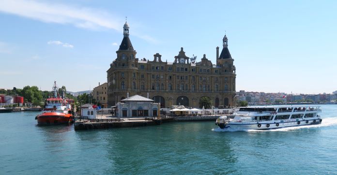 Blick von einer Fähre auf dem am Bosporusufer gelegenen Haydarpasabahnhof und eine andere weiße Fähre