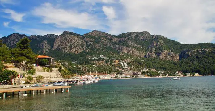Ein Steg führt ins Türkisblaue Wasser einer Bucht in der Türkei.