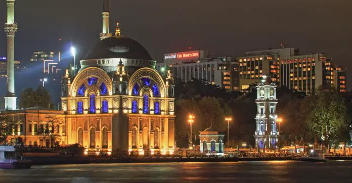 Aufnahme der Dolmabahce Moschee vom Bosporus. Die Moschee ist mit Lampen hell erleuchtet. 