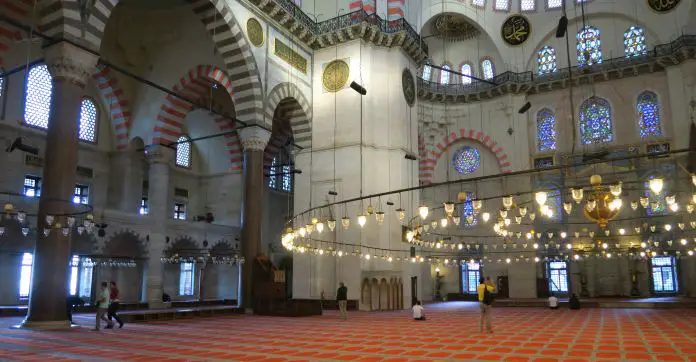 Rote Teppich und die weißen Wände mit roten Verzierungen im Inneren der Süleymaniye Moschee