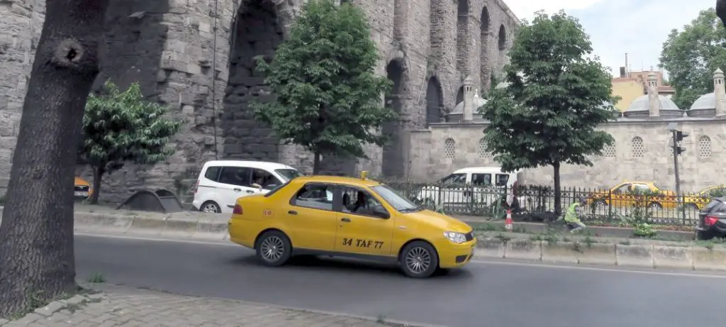 Gelbes Taxi auf der Straße vor dem Aquädukt in Istanbul