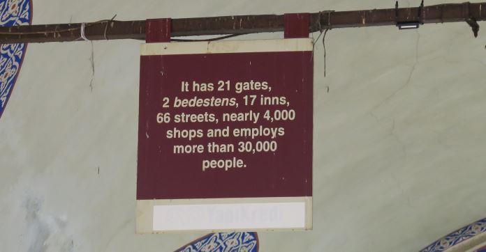 Schild in roter Farbe mit goldener Schrift: "Der Große Basar hat 21 Tore, 2 Halen, 17 Höfe, besteht aus 66 Straßen, 4000 Geschäften und es arbeiten mehr als 30000 Menschen in ihm.