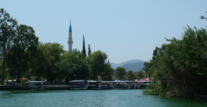 Die Boote am Ufer des Dalyan Fluss im Dorfzentrum und das Minarett der Moschee.