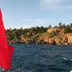 Die türkische Flagge hängt am Heck eines Bootes an einem Feiertag in der Türkei. Aufgenommen vor den Klippen von Antalya.