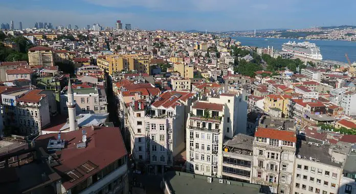 Blick vom 80m hohen Galataturm auf die darunterliegenden Häuser im Stadtteil Beyoglu, den Bosporus auf der rechten Bildseite mit einem Kreuzfahrtschiff und der Istiklal Caddesi.