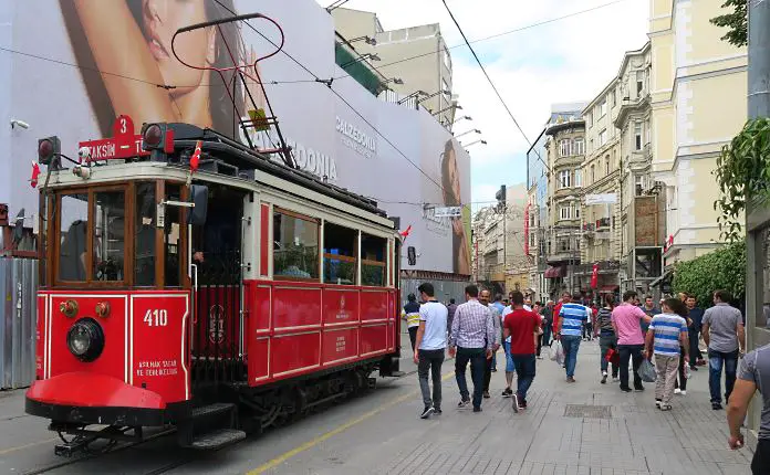 Rote Straßenbahn mit Fußgängern mit Blick auf die Istiklal Caddesi