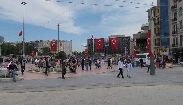 Menschen spazieren am Taksim Platz in Istanbul entlang.