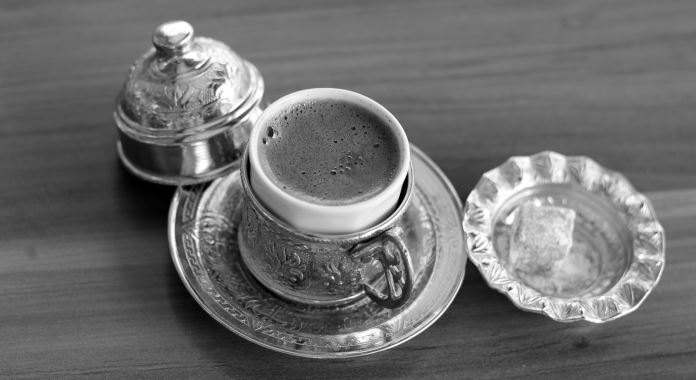 Ein schwarz-weiß Bild einer türkischen Kaffeetasse mit türkischen Mokka und einem Stück türkischen Honig.