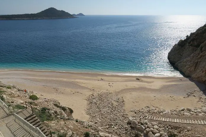 Blick auf den unterhalb einer Felswand gelegenen Kaputas Beach mit dem türkisblauen Wasser des Mittelmeeres. 