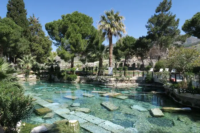 Das türkisblaue Thermalwasser im kleinen mit Palmen umringten Kleopatra Pool in Pamukkale-Hierapolis. 