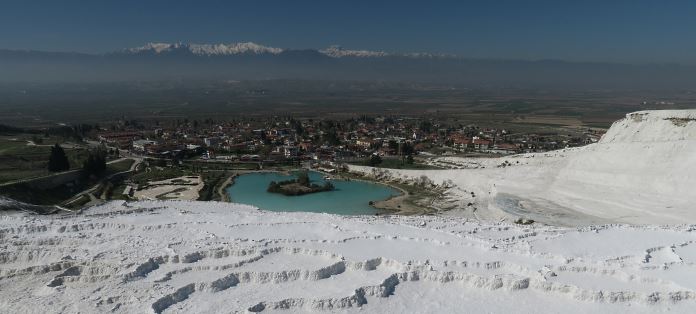 Die schneeweißen Kalkterrassen von Pamukkale mit den schneebeckten Berggipfeln im Hintergrund. 