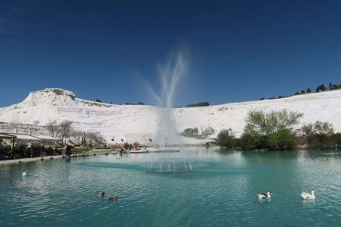 De schneeweißen Kalkterrassen von Pamukkale und der türkisblaue See unterhalb der Terrassen. 