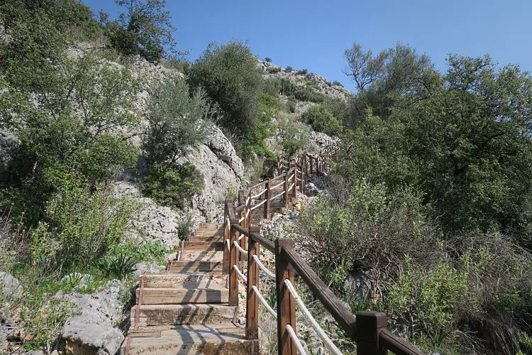 Die Holz- und Steintreppen, die an einem steilen Hügel zur Karain Höhle hinaufführen. 