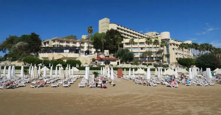 Eine Clubanlage steht am öffentlichen Strand in der Türkei. Dort sind Liegestühle und Sonnenschirme mit Badegästen zu sehen.