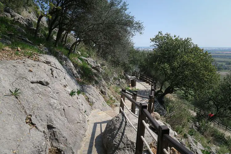 Der mit Steinplatten und einem Holzgeänder ausgestattete Weg zur Karain Höhle in Antalya. 