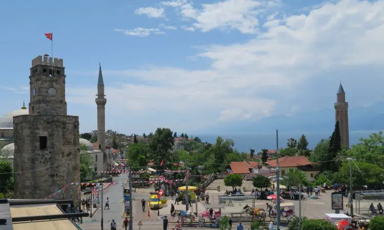 Der Uhrturm von Antalya am Tag mit dem Meer im Hintergrund. 