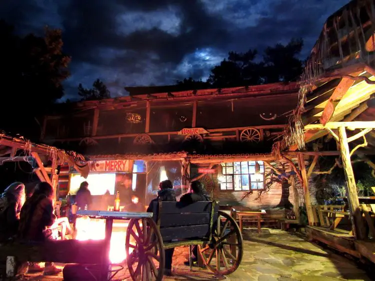 Ein Lagerfeuer brennt in der Nacht in Kadir´s Tree House. Es sitzten Menschen rund um das Feuer. 