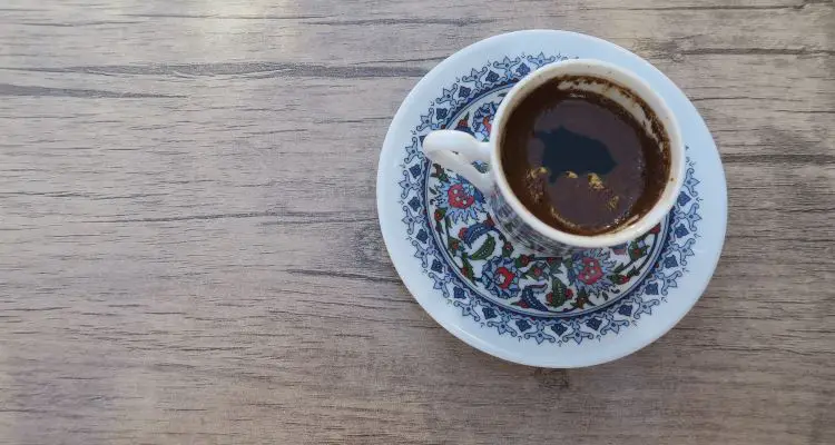 Eine kleine Tasse mit türkischen Mokka steht auf einem Tisch.