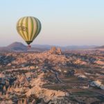 Der Blick aus einem Heißluftballon auf einen anderen Ballon und die Festung Uchisar in Kappadokien.