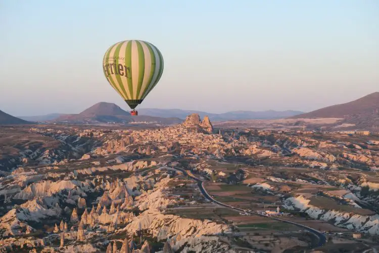 Der Blick aus einem Heißluftballon auf einen anderen Ballon und die Festung Uchisar in Kappadokien. 