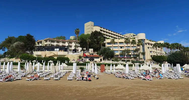 Eine All-Inclusive Clubanlage am Sandstrand von Side-Kumköy. Aufgenommen vom Meer aus. Man sieht die Liegestühle, die Clubanlage und den Sandstrand.