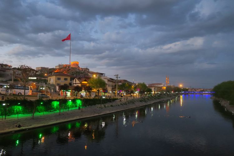 Ein Bild des Roten Fluss Fluss in Avanos in der Nacht. Die Lichter der nahen Innenstadt spiegeln sich im Wasser des Flusses. 