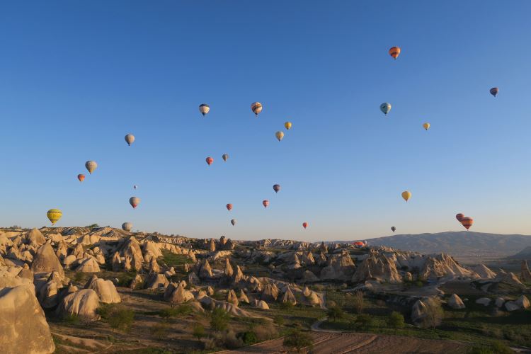 Ein Bild mit dutzenden, bunten Heißluftballonen am Himmel über Kappadokien. 