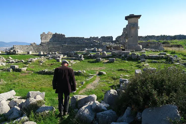 Ein Reiseführer mit dem Theater in den Ruinen von Xanthos. 