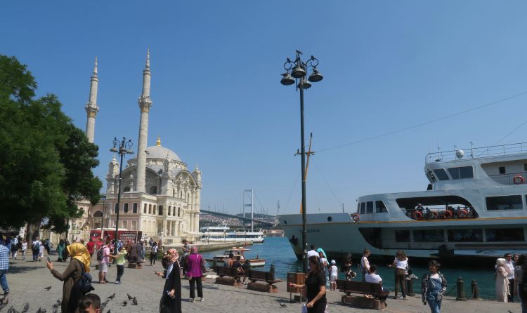 Die Ortaköy Moschee mit dem Bosporus, Tauben und der Bosporusbrücke im Hintergrund.