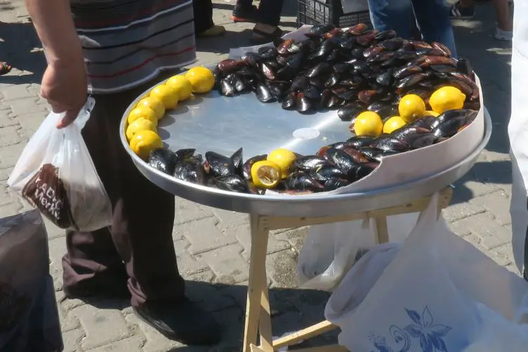 Midye Dolma liegen auf einer kleinen Silberplatte zusammen mit Zitronen. 