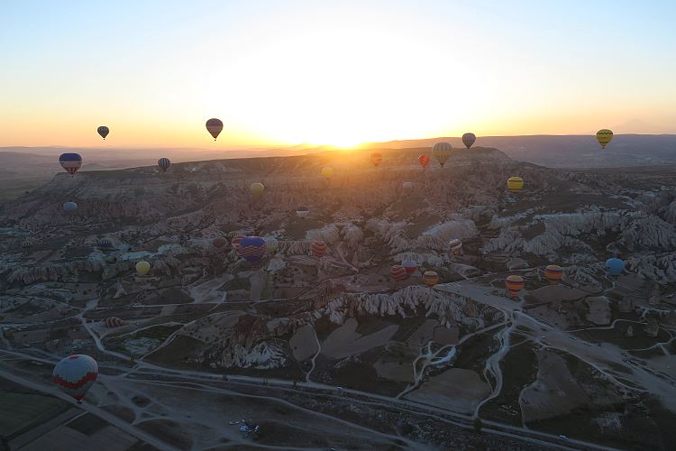 Die Sonne geht hinter einem Berg in Kappadokien auf. Das Bild stammt aus einem Heißluftballon, der 1.000m über Kappadokien schwebt.