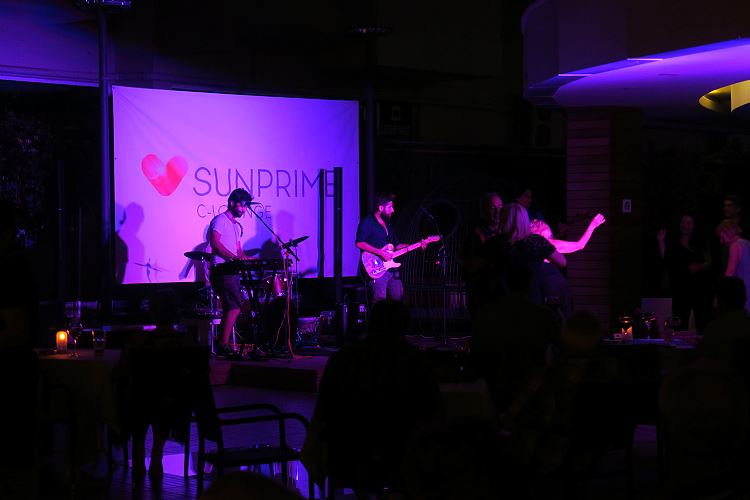 Neben dem Pool steht eine Bühne mit einer Band am Abend.