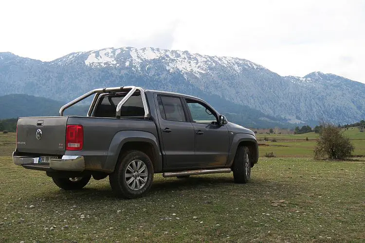 Ein Pick Up Jeep steht auf einer weiten Wiese im Taurusgebirge. Auf den Bergen liegt noch Schnee.