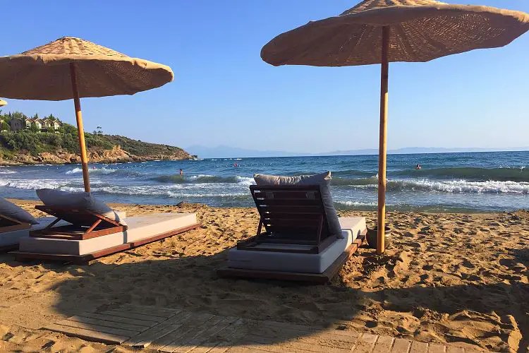 Die Sonnenliegen und Sonnenschirme am Sandstrand des Club Marvy Özdere am Tag bei schönem Wetter. 