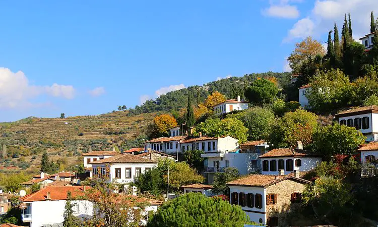 Ein idyllisches Dorf mit griechischen Holzhäusern an einem Berghang. 